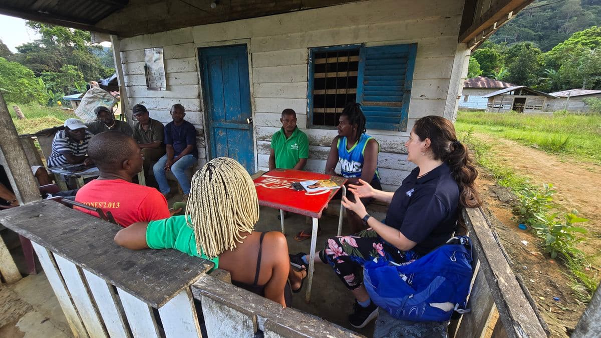 A group of people sitting on the porch of a wooden house